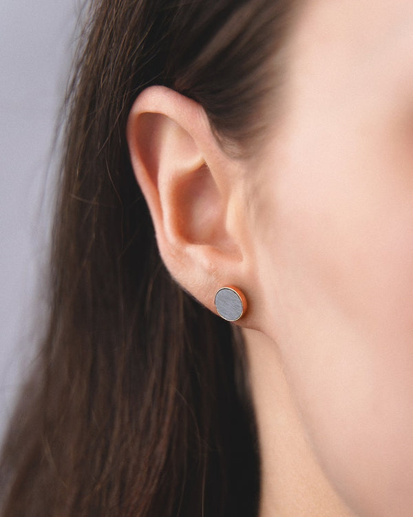Model wearing Cosmic earrings - Handcrafted birch wood and sterling silver studs with a  luna grey birch wood interior, plated with 24k gold.
